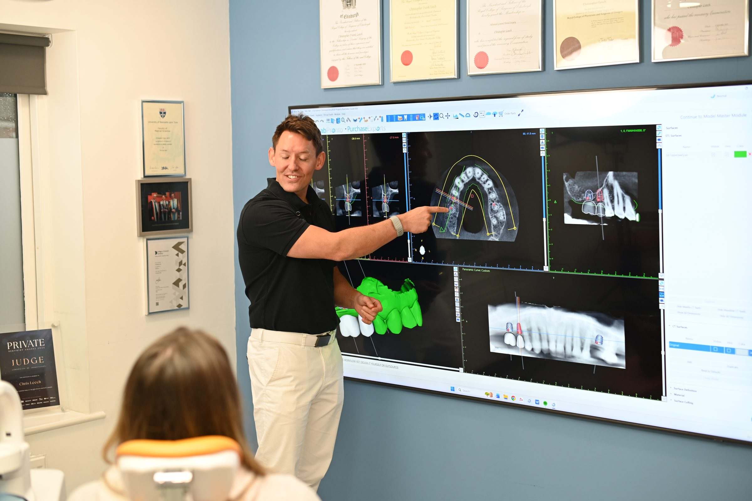 Dr Chris Leech explaining a full-arch implant plan in 3D to a patient