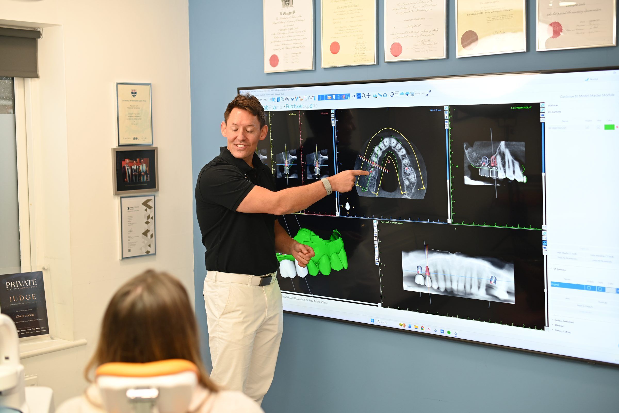 Dr Chris Leech explaining a full-arch implant plan in 3D to a patient