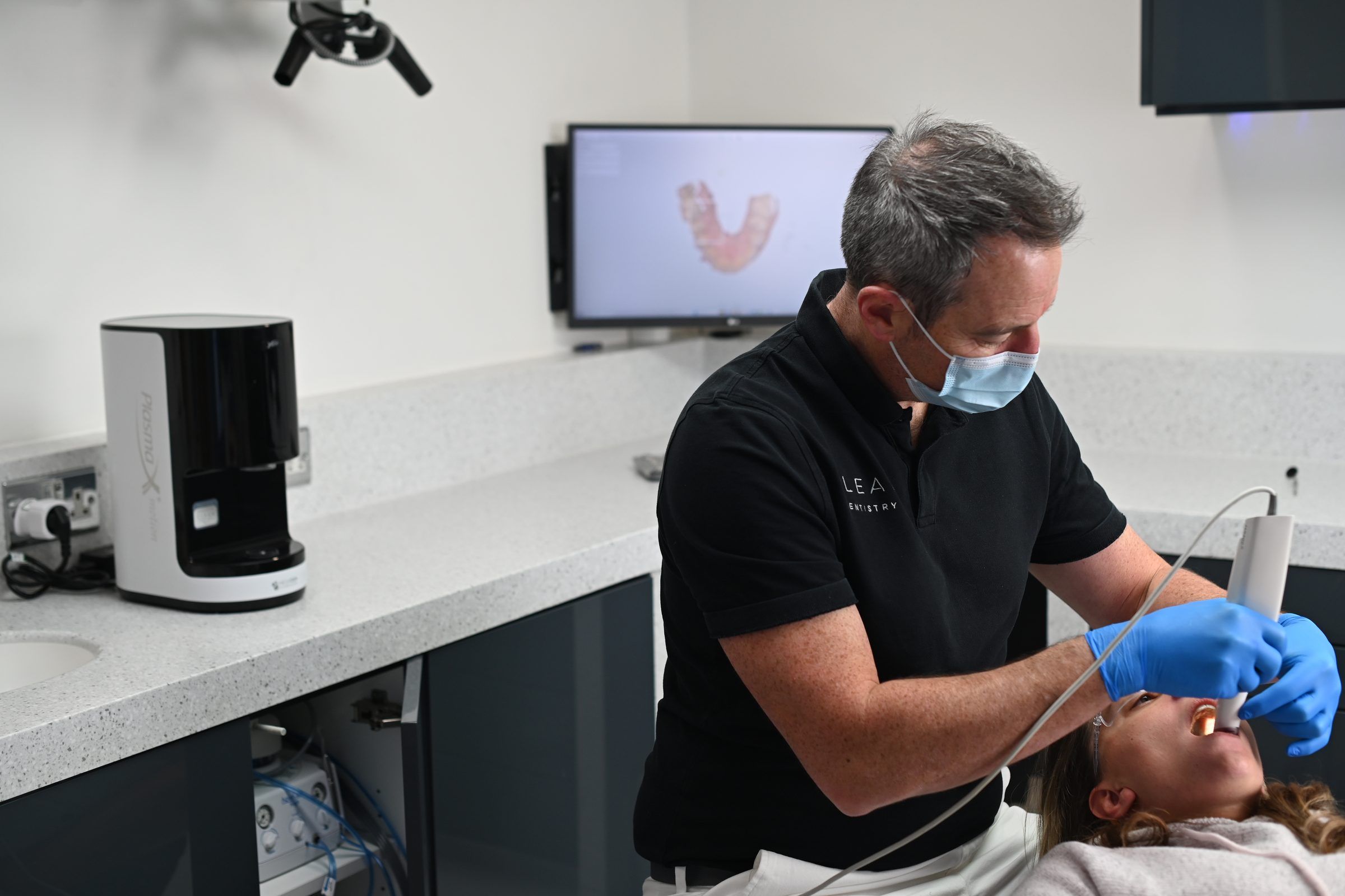 Dr Leigh Knowles scanning a patient's teeth with the iTero scanner for clear aligner planning